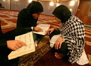 Hajira Khan, 12, gets help reading the Quran from her older sister Amena, 16. The Khan family prays and studies at the Jam-e-Masjid Islamic Center in Boonton.