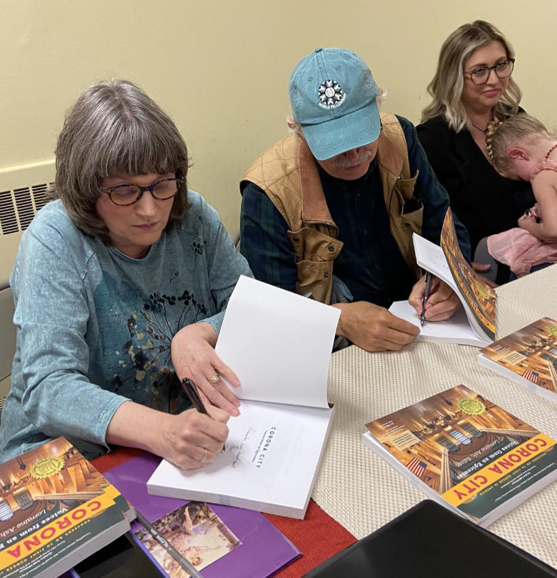 Authors signing books at a Corona City event